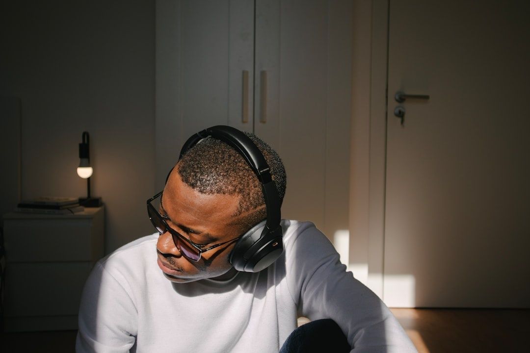 Man met bril en koptelefoon zit geconcentreerd in een rustige kamer