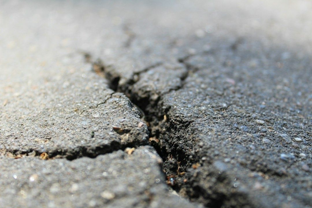 Close-up van een diepe scheur in een ruw betonnen oppervlak